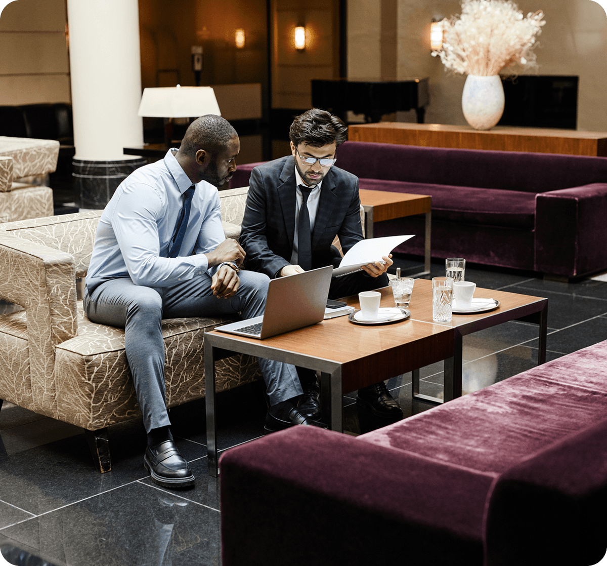 Two men discussing documents in office setting