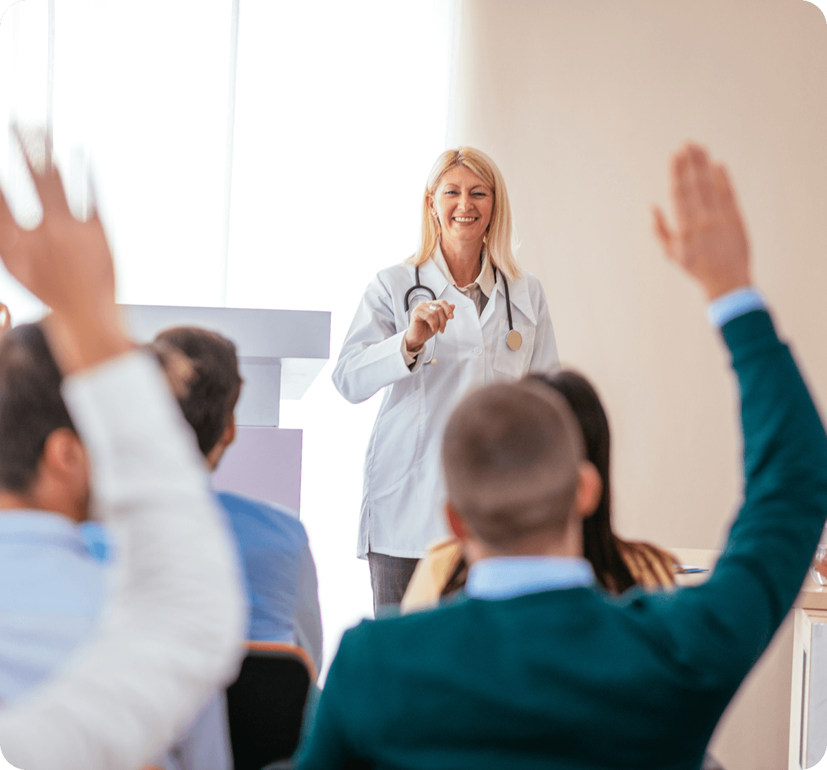 Doctor speaking to audience with raised hands